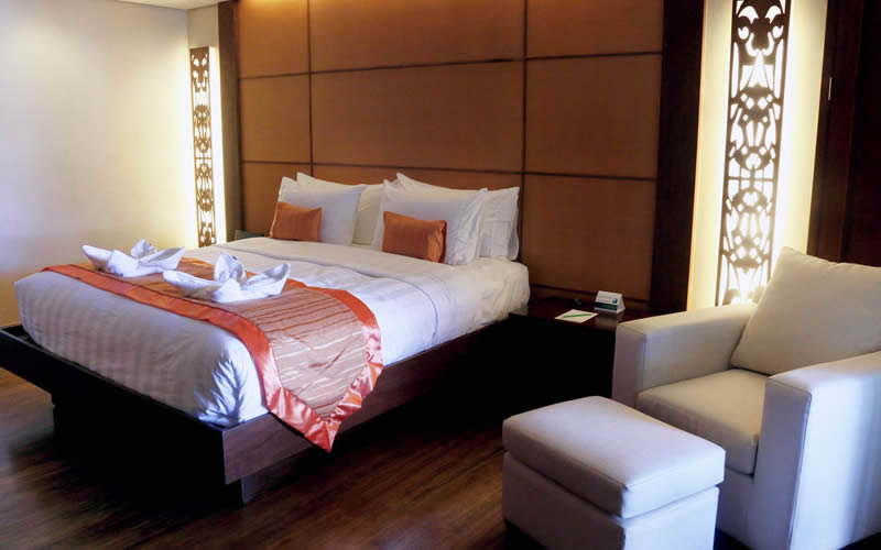 A beachfront casita bedroom with carved screens.