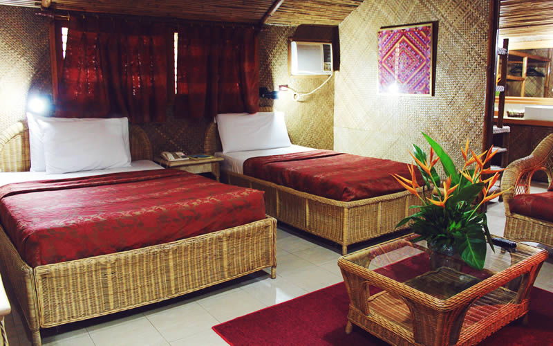 A deluxe room with a queen bed and warm timber ceiling.